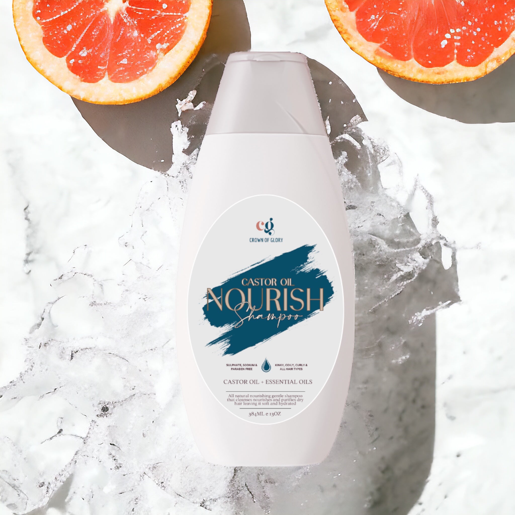 A bottle of the Crown of Glory Nourish Castor Oil Shampoo sits against a splash of water. Two halved pink grapefruits add a fresh and vibrant touch to the scene, emphasizing its sulphate-free formula that revitalizes your hair.